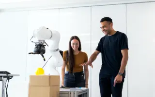 two people working with a robotic arm