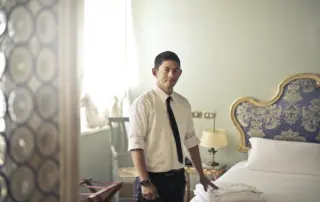 a luxury hotel staff member makes a bed