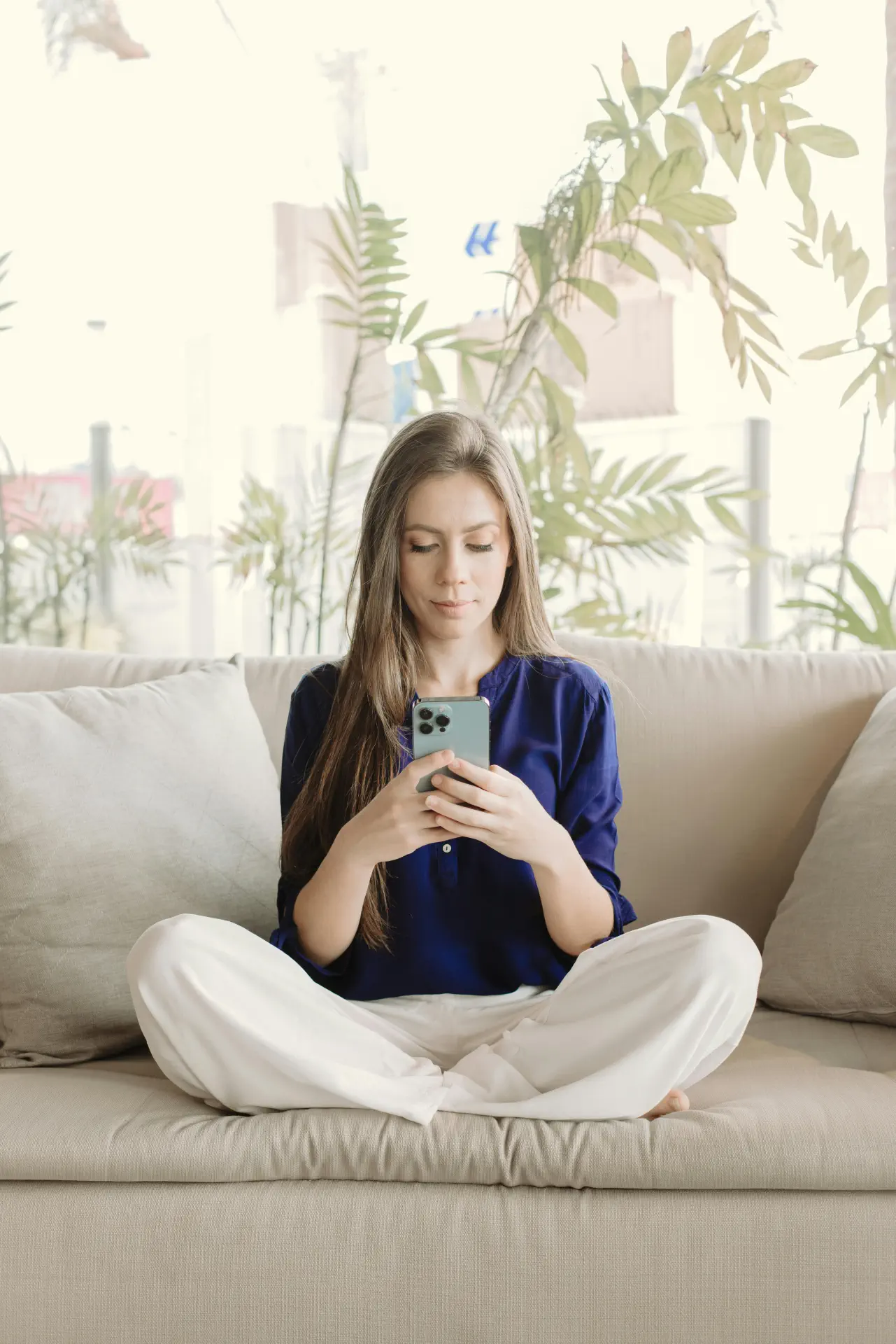 a woman using a phone on a couch