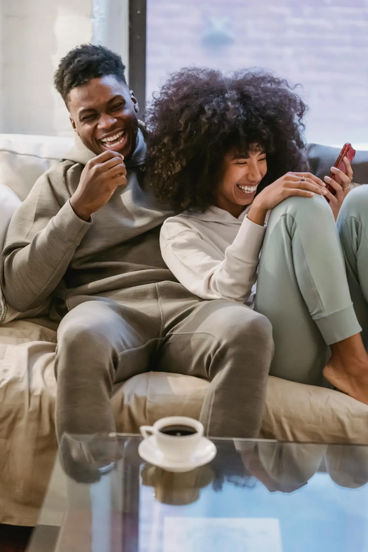 couple on a couch with phones showing telecom loyalty